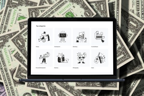 A MacBook Air displaying various skill categories on the screen, with dollar bills in the background